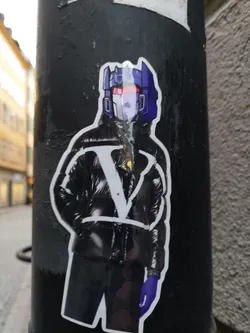 A sticker featuring a stylized illustration of a person wearing a black puffer jacket and gloves, with a Transformers character's helmet as their head. The design blends pop culture elements with fashion.