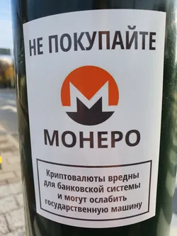 A sticker warning against purchasing Monero cryptocurrency. It features the Monero logo and text in Russian.