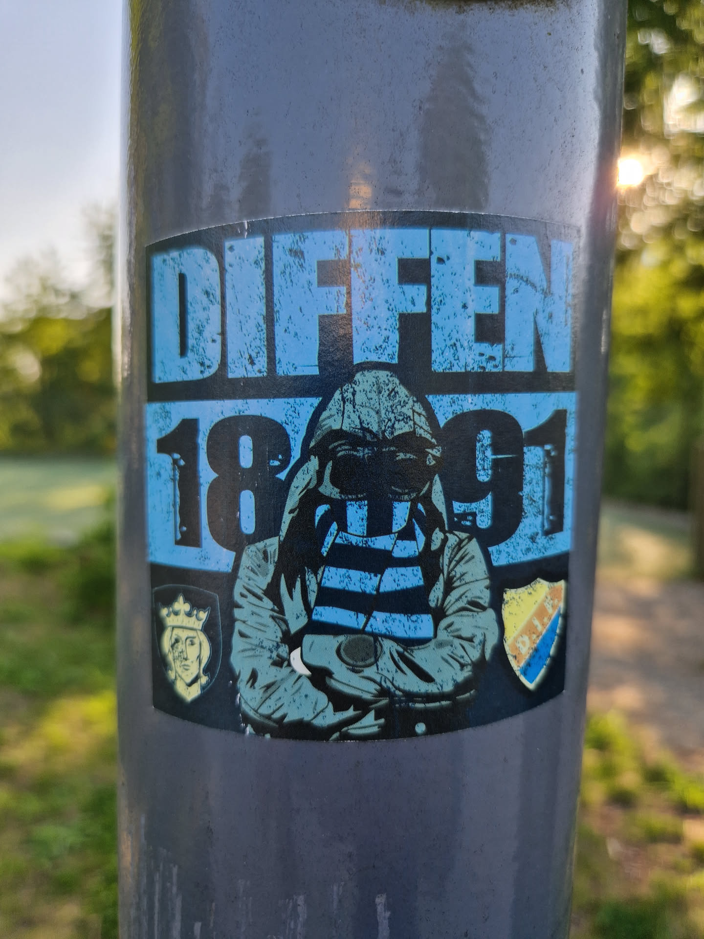 Sticker featuring a hooded figure with a striped scarf, the text "Diffen 1891", and two crests. The style is gritty and vintage.