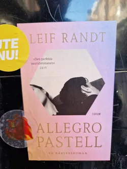 Book cover sticker for the novel "Allegro Pastell" by Leif Randt. The sticker features a pastel pink and purple color scheme with a black and white photo of two people.  The text on the sticker includes the author's name, the title, and a description of the book as "a perfect contemporary novel".