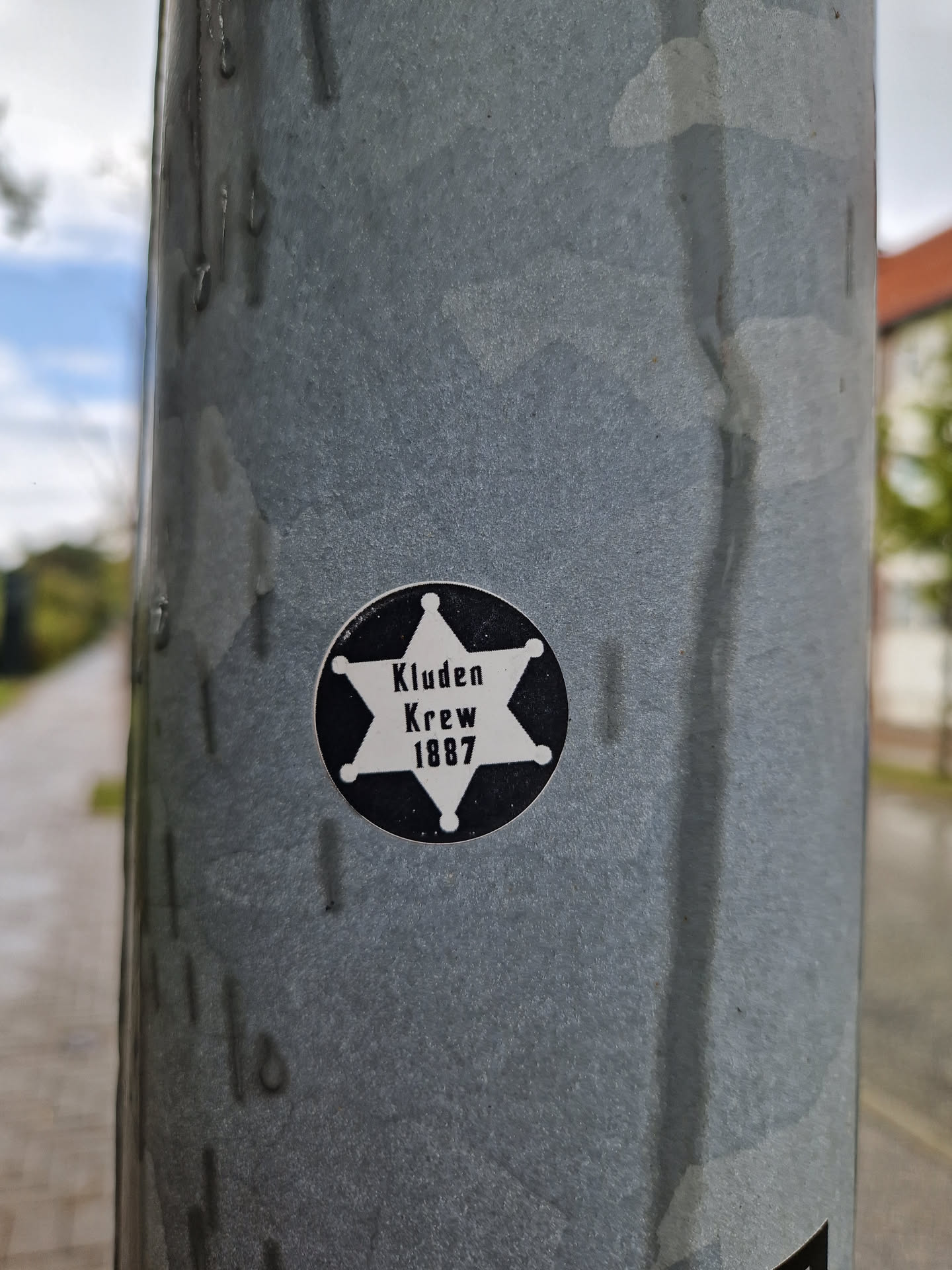 A black and white circular sticker with a sheriff's badge design.  It features a five-pointed star with the text 'Kluden Krewe 1887' inside.
