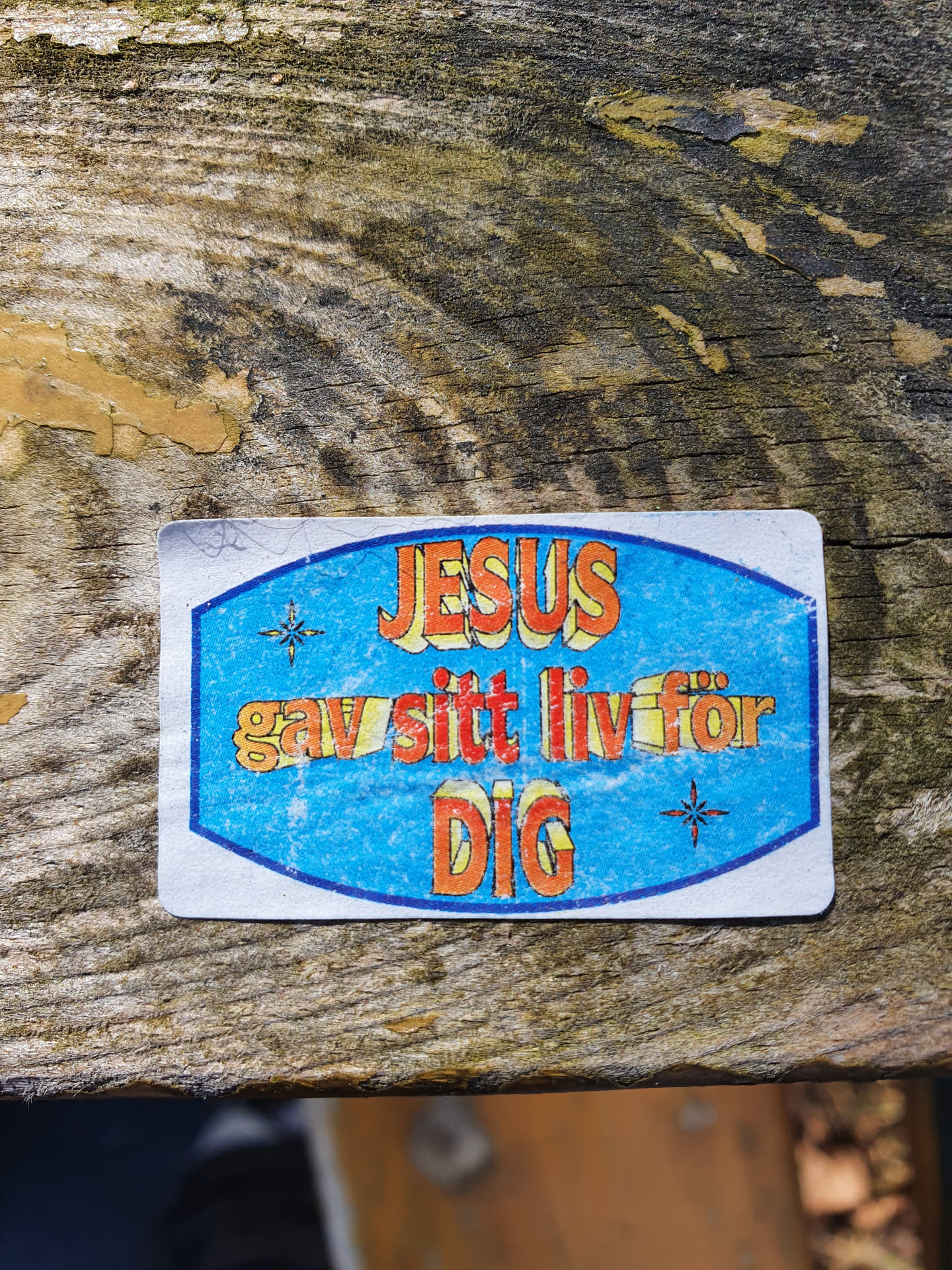 A religious sticker with a blue background and orange text. It says "Jesus gav sitt liv för dig" which translates from Swedish to English as "Jesus gave his life for you".