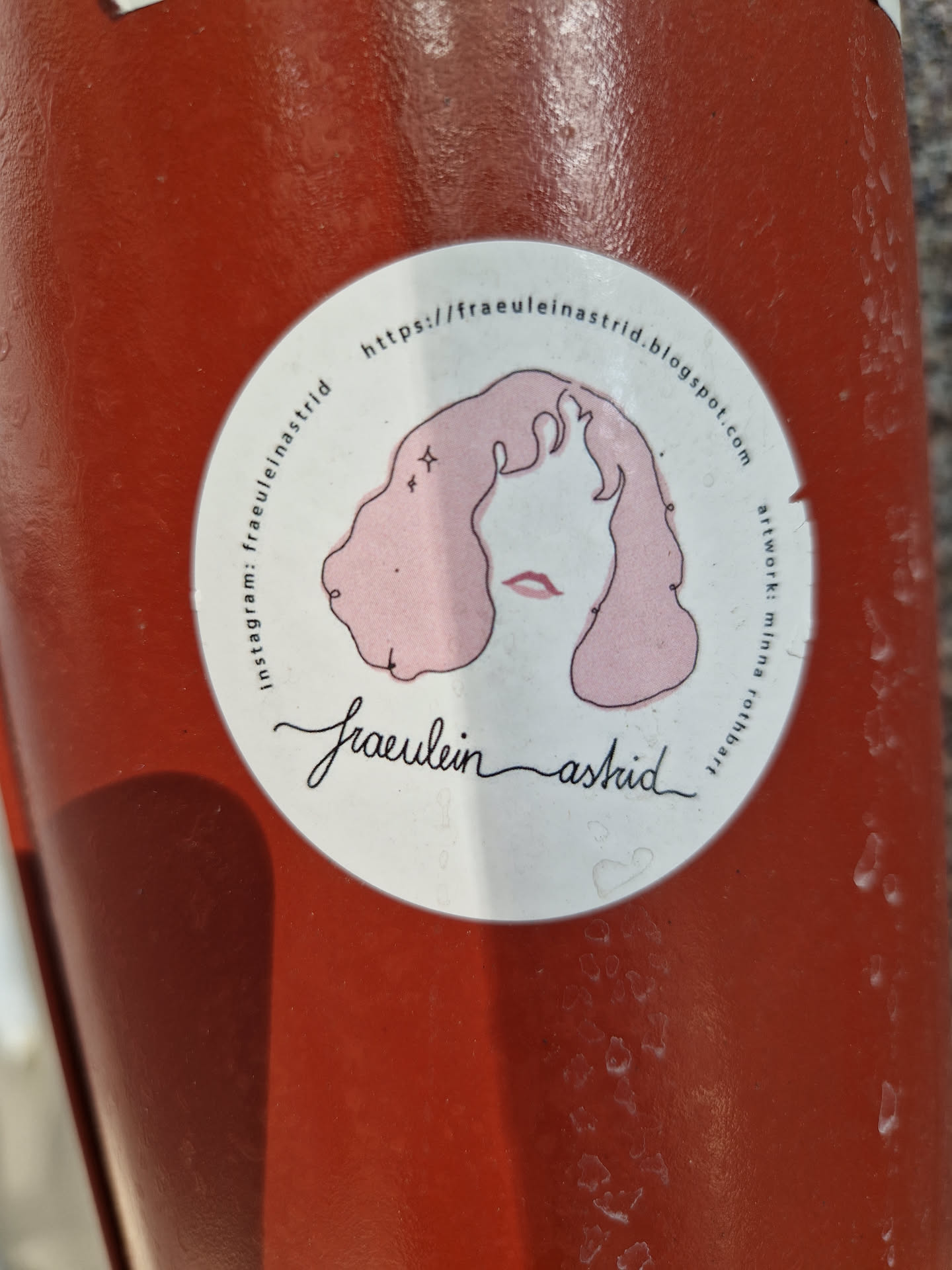 Round sticker with illustration of a girl with pink hair and the text Fraeulein Astrid.  It also contains a blogspot URL.