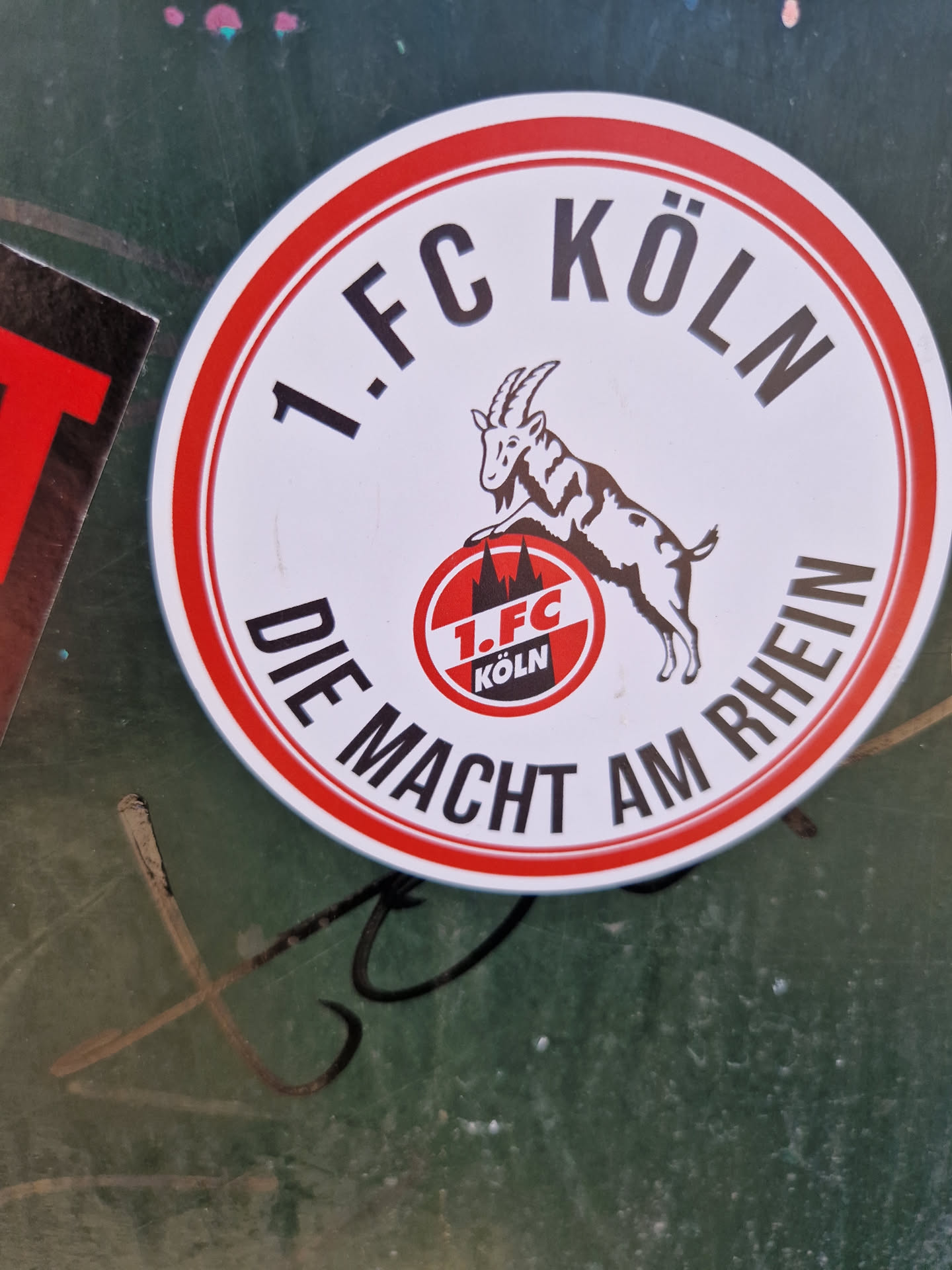 Round sticker featuring the logo of 1. FC Köln, a German football club.  The sticker shows a goat, the club's mascot, and text that reads '1. FC KÖLN DIE MACHT AM RHEIN' which translates to '1. FC Cologne The Power on the Rhine'.