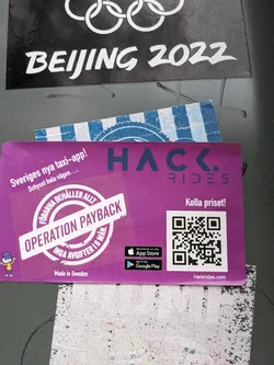 A purple sticker advertising Hack Rides, a new taxi app in Sweden.  The sticker features a QR code, App Store and Google Play download links, and the slogan "Operation Payback" indicating drivers keep all the fares. 