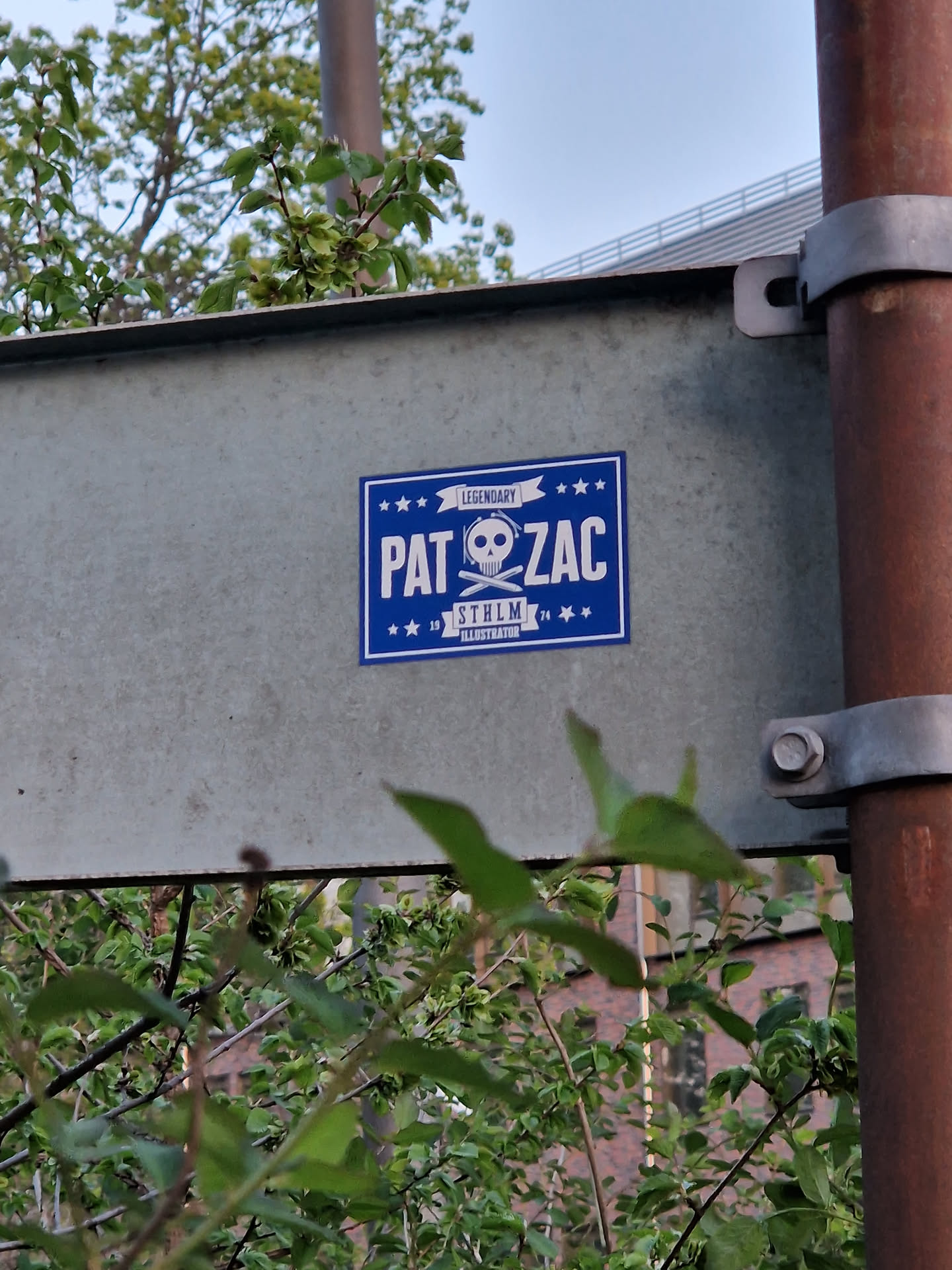 A blue square sticker with a skull and cross drumsticks graphic. It says Pat & Zac with Legendary written above and Stockholm underneath.
