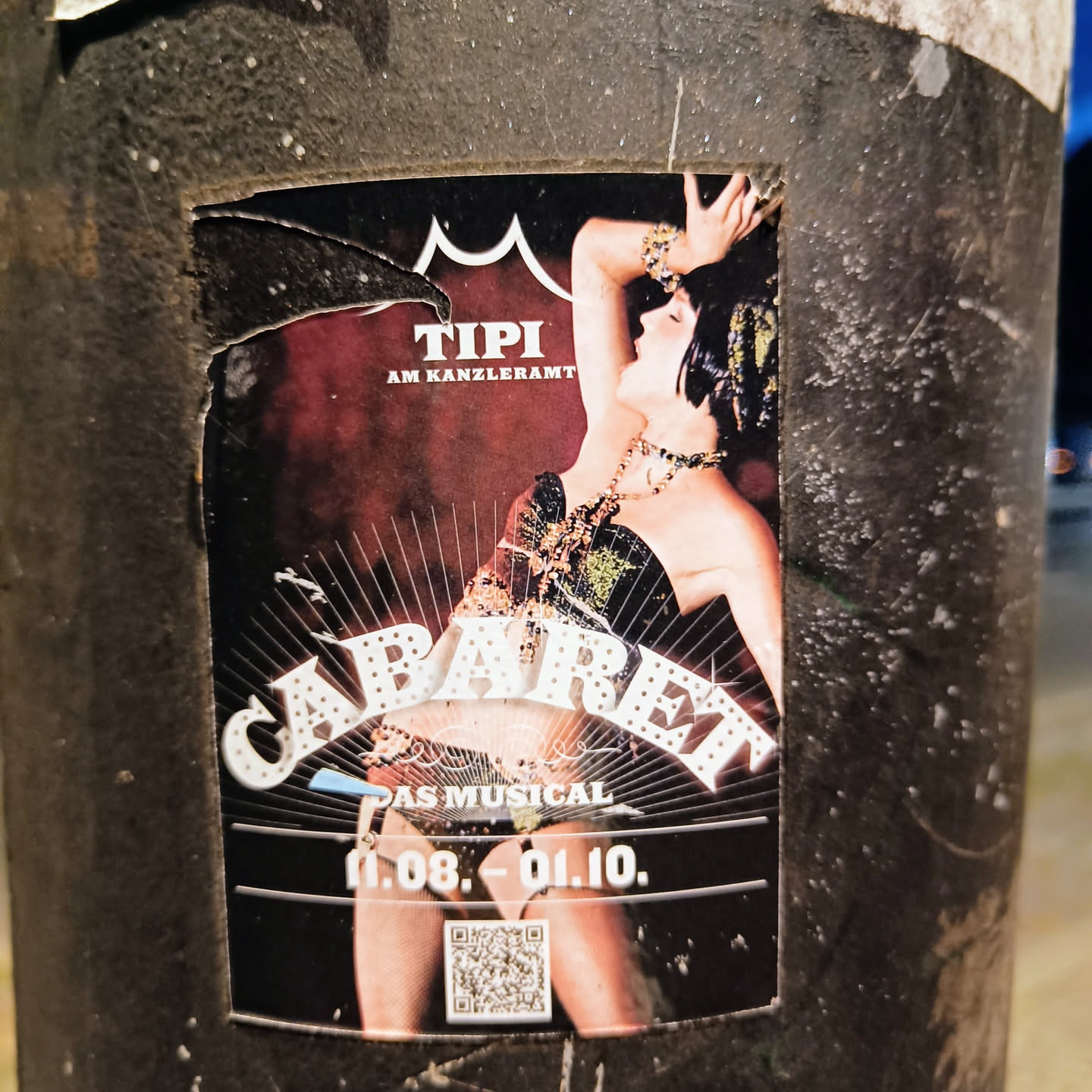 A sticker advertising the musical Cabaret playing at the Tipi am Kanzleramt from August 11th to October 1st.  The sticker features an image of a showgirl in a cabaret style pose. A QR code is also present.