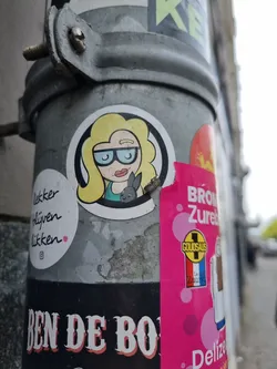 Round sticker featuring a cartoon drawing of a blonde woman wearing glasses and holding a small rabbit. The style is simple and slightly minimalist, with a focus on clean lines and muted colors. 