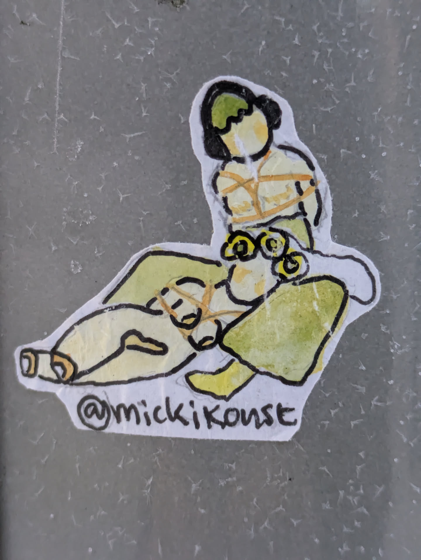 A small sticker with an illustration of a person tied up, drawn in a simple, watercolor-like style. The artwork is lighthearted, with muted colors and simple lines. The sticker includes the artist's Instagram handle.