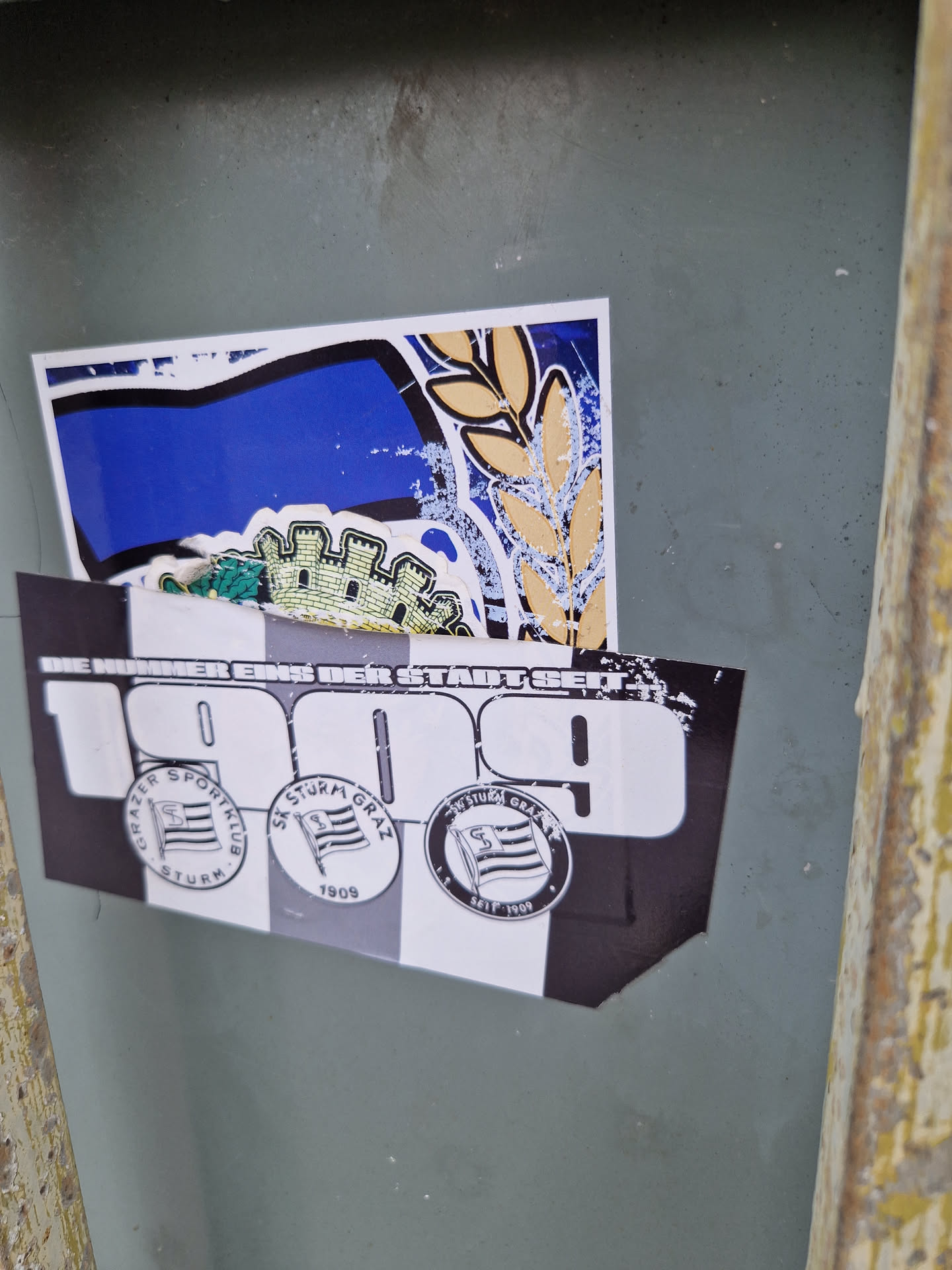 A sticker commemorating the 1909 founding of SK Sturm Graz, an Austrian football club. The sticker features the club's logo and the year 1909.  There's also additional imagery above it that appears to be related to the club.