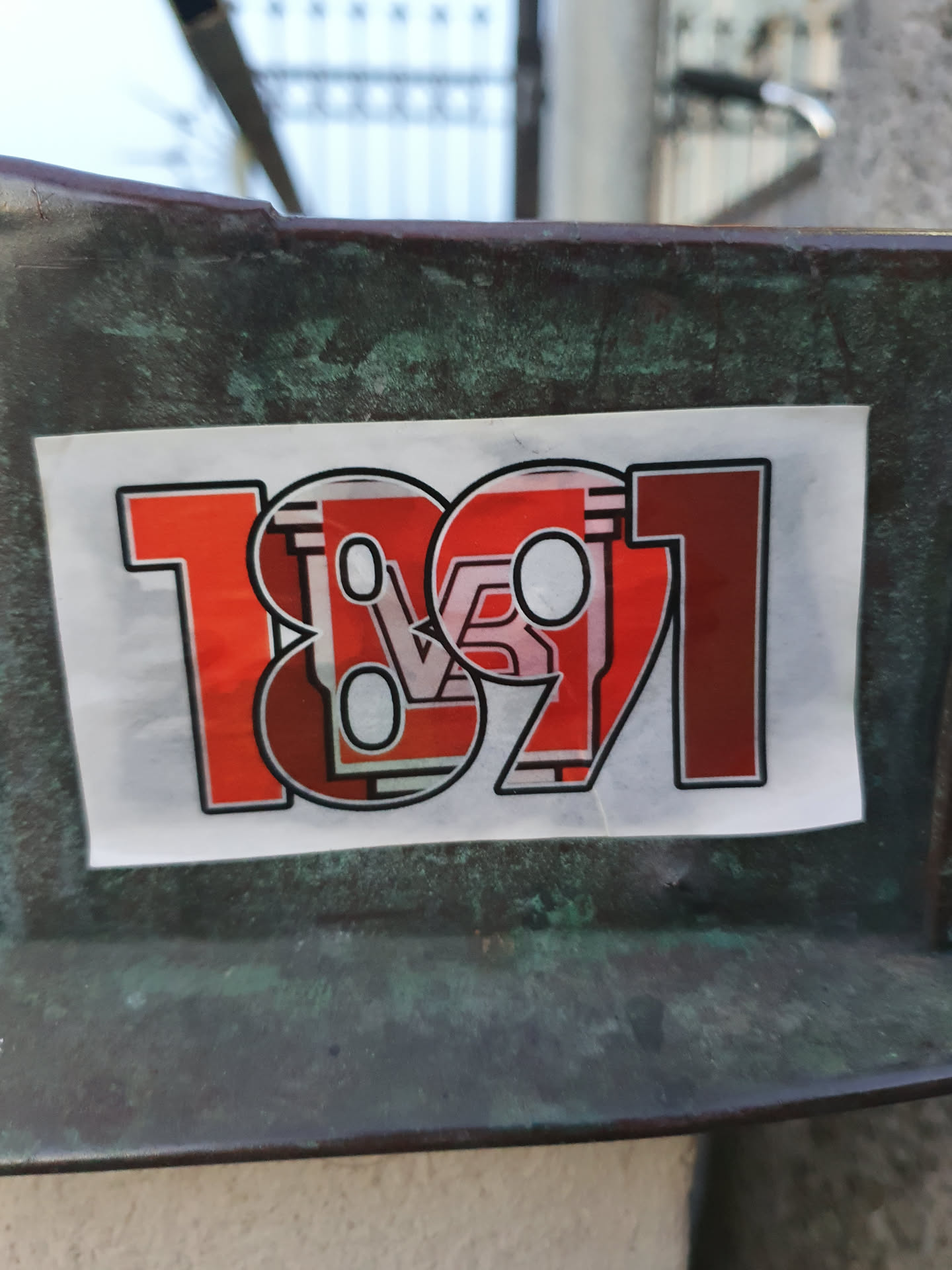 Red and white sticker with the number 1891. The design incorporates a stylized representation of the number, possibly referencing a year or date.