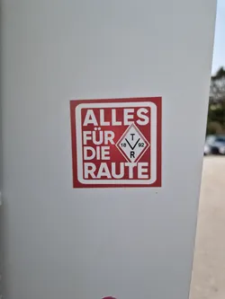 A red square sticker with white text that says "Alles für die Raute" and a small symbol inside. The text translates to "Everything for the rhombus".