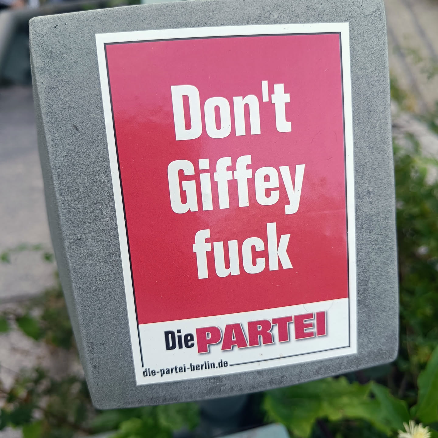 A red sticker with white text that says "Don't Giffey fuck" and the logo of the German political party "Die PARTEI".  The sticker is affixed to a gray surface. The text "die-partei-berlin.de" is at the bottom.