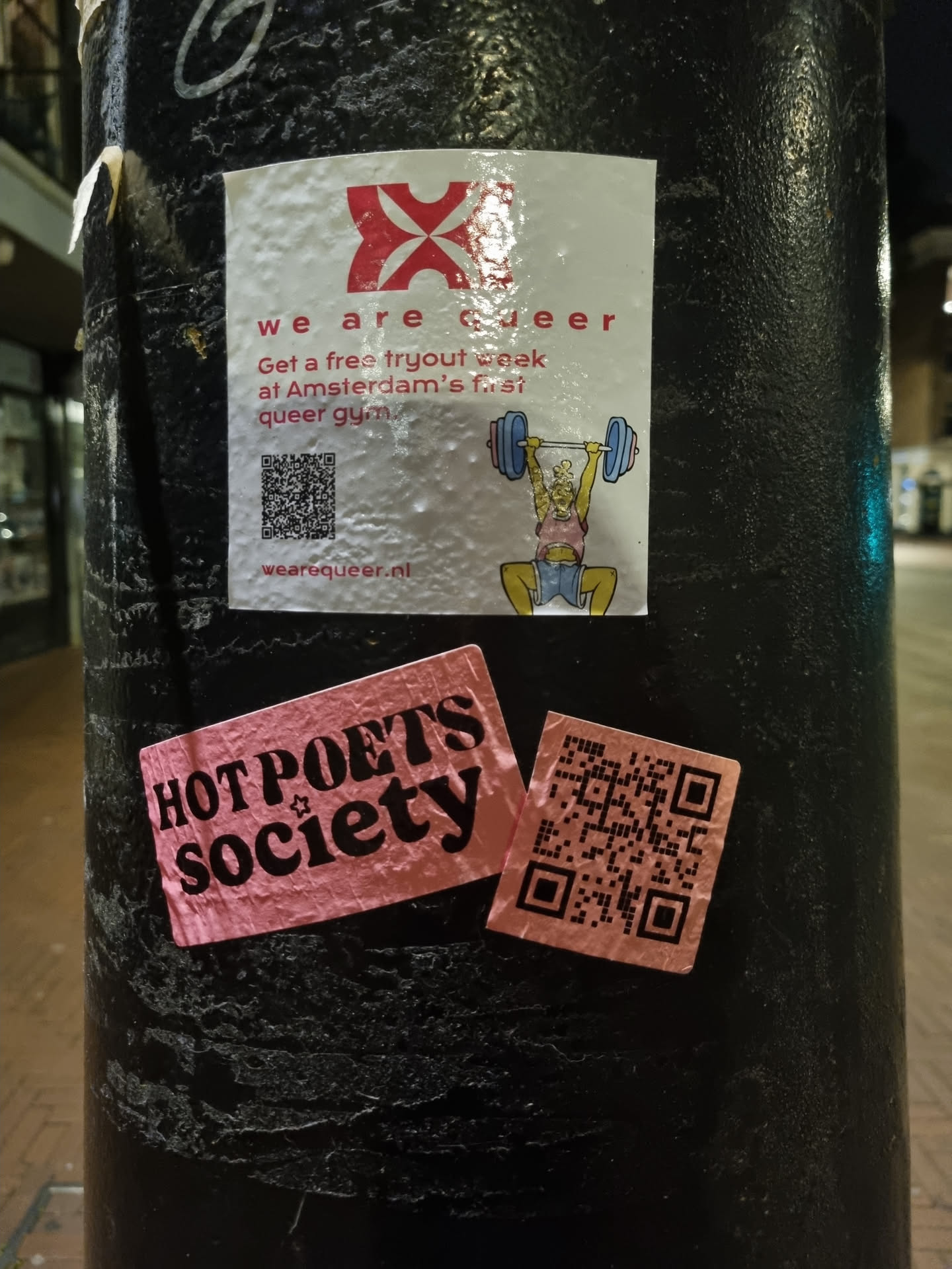 Pink sticker with the text Hot Poets Society and a QR code.  There is another sticker above it advertising a free tryout week at Amsterdam's queer gym.