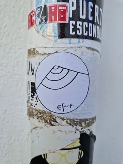 A round white sticker with a simple black line drawing of a wave. The artist's signature, @Tacifo, is written in cursive at the bottom.