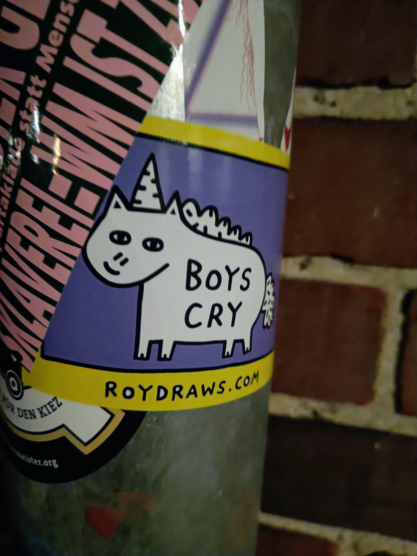 A purple sticker featuring a cartoon unicorn with the text 'Boys Cry' and a website address at the bottom. 