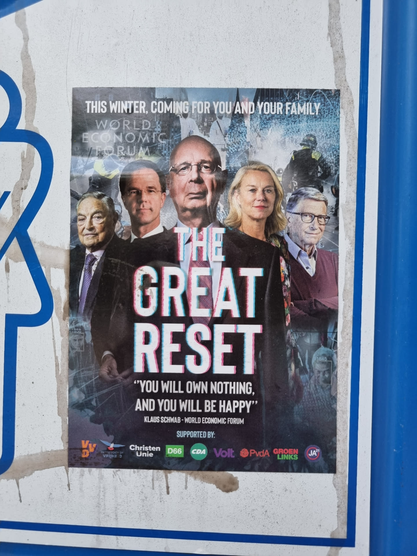 A sticker depicting a poster about the Great Reset conspiracy theory. It features prominent figures and the quote "You will own nothing, and you will be happy." Logos of several political parties are visible at the bottom. 