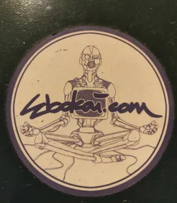 Round sticker featuring a robotic figure in a meditative pose. The robot has a screen for a chest and is drawn in a vintage style.  The website zbdkai.com is written under the illustration.