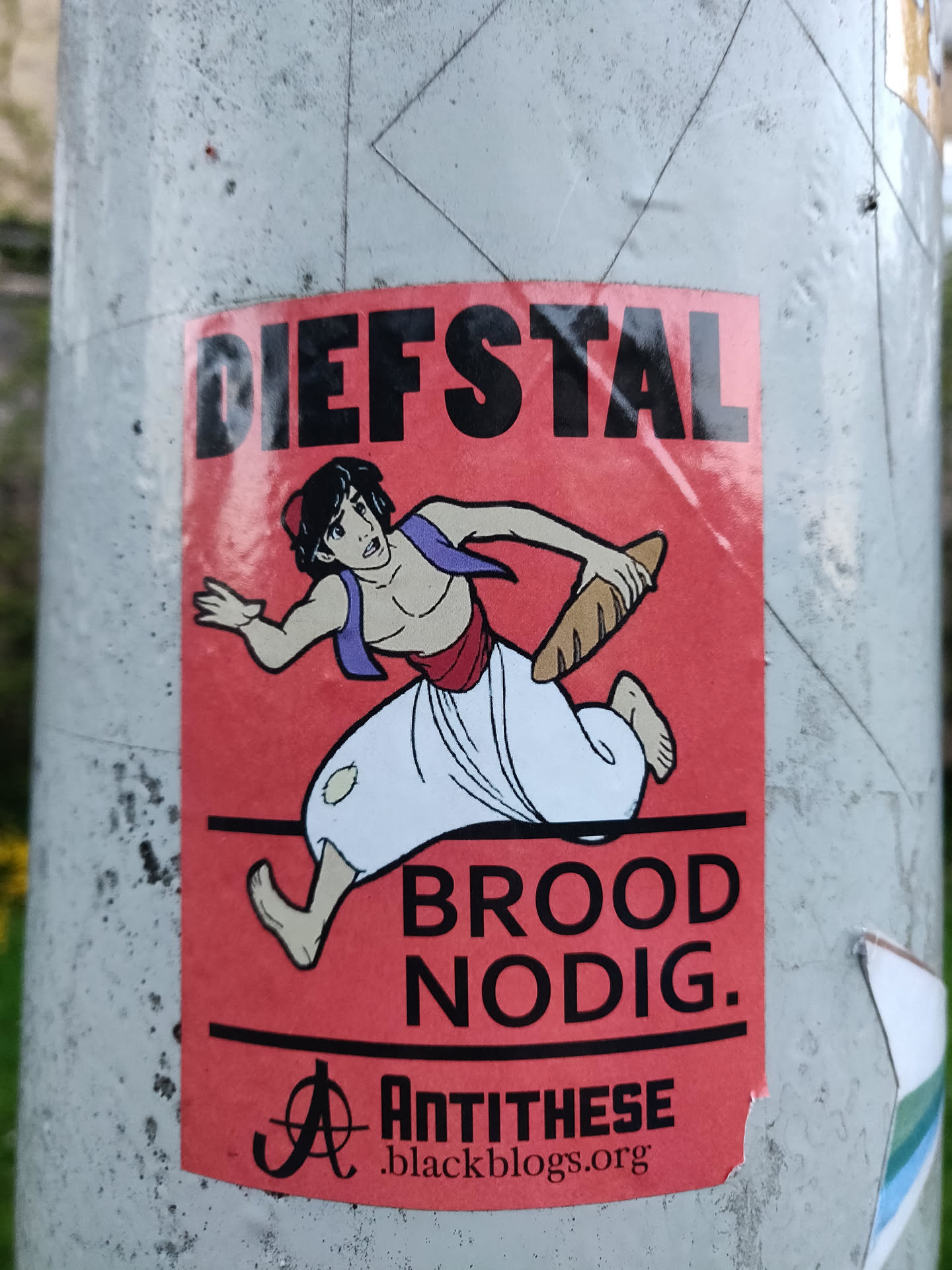 A sticker featuring Aladdin from Disney's Aladdin running with a baguette, with the text "Diefstal Brood Nodig." which translates from Dutch to "Theft Bread Needed."
