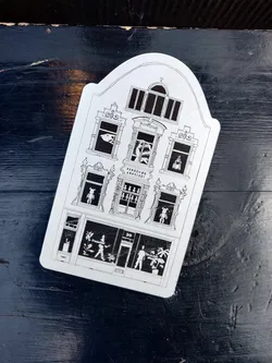 This sticker features a black and white illustration of a building with arched windows and a storefront. The windows show various scenes, including a shark, a bear, and people shopping. The building number is 30. 
