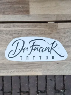 A sticker featuring the logo for Dr. Frank Tattoo. The logo is written in a stylized script font on a white background.