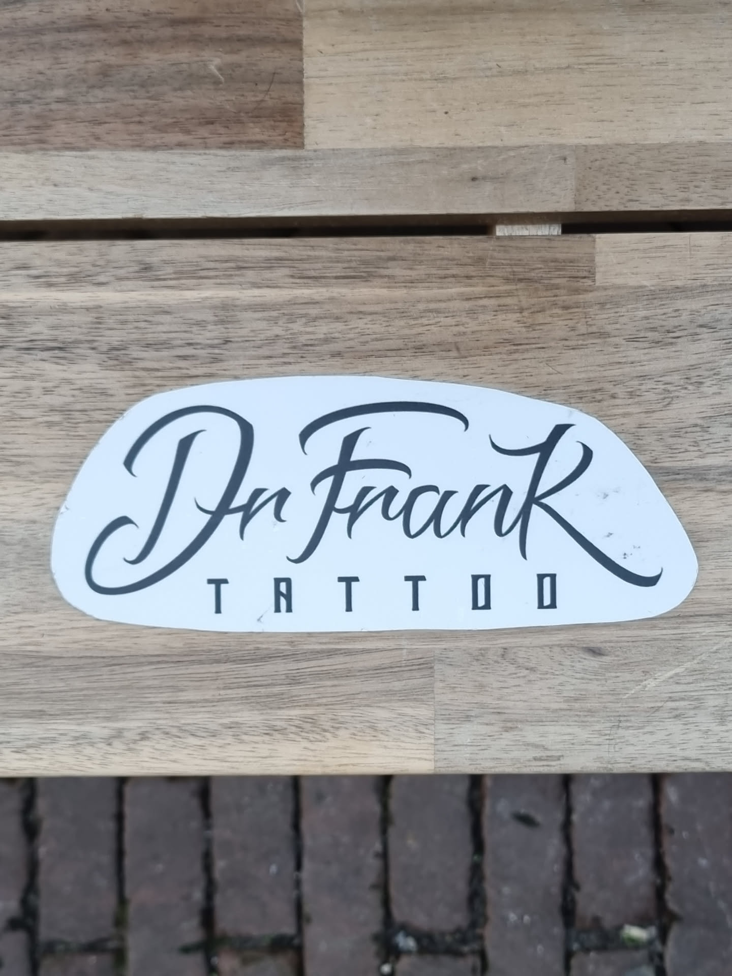 A sticker featuring the logo for Dr. Frank Tattoo. The logo is written in a stylized script font on a white background.