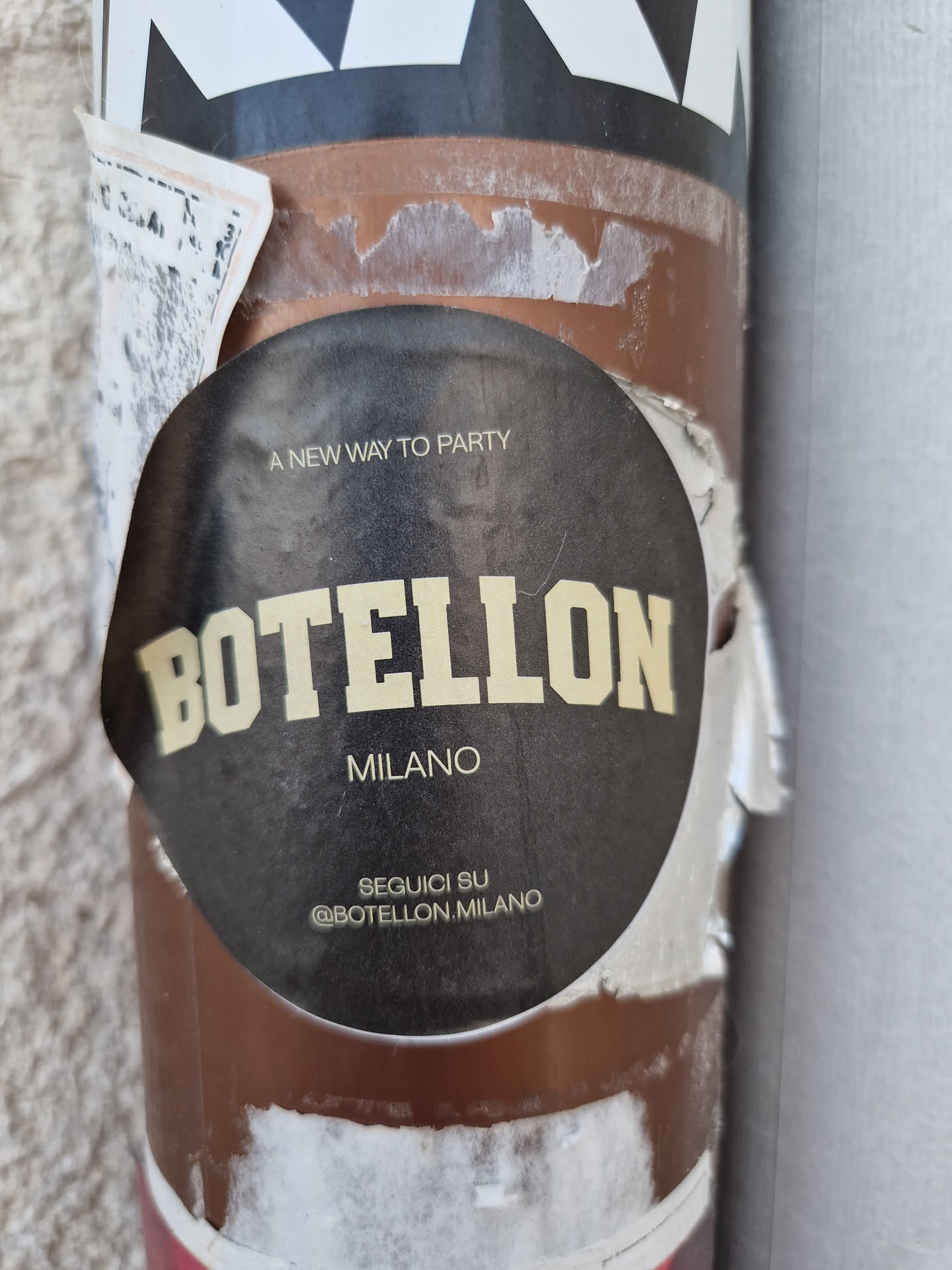 Round black sticker with the text BOTELON MILANO in yellow.  It also says "A new way to party" and has the Instagram handle @BOTELON_MILANO.