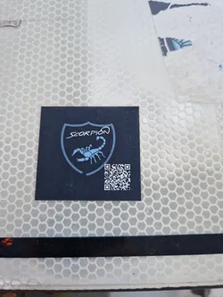 Black sticker with a scorpion in a shield and a QR code. The word SCORPION is written above the scorpion.
