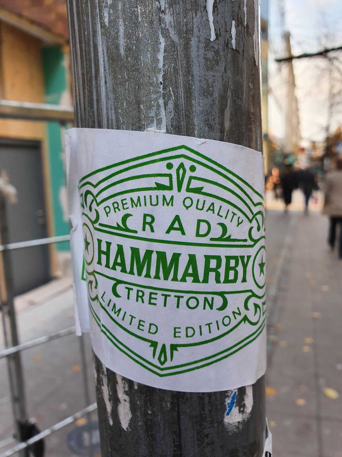 A green and white sticker with the text 'Premium Quality Craft Hammarby Tretton Limited Edition' and a unique design. It's a limited edition item, suggesting exclusivity. The sticker is affixed to a metal pole outdoors.