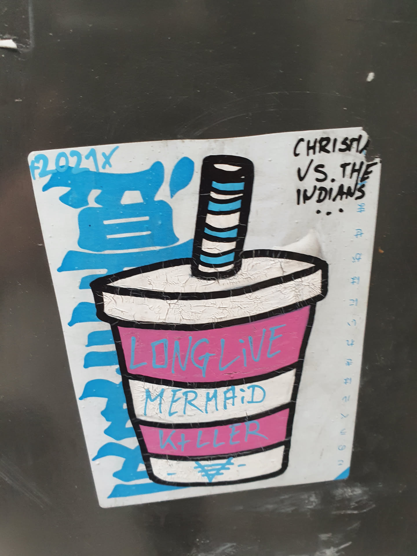 A sticker featuring a stylized illustration of a cup with the text "Long Live Mermaid Killer" written on it.  There's additional text on the sticker that appears to be part of an artist's signature or series and some additional text that says "CHRISTY VS. THE INDIANS". The style is reminiscent of graffiti or street art.