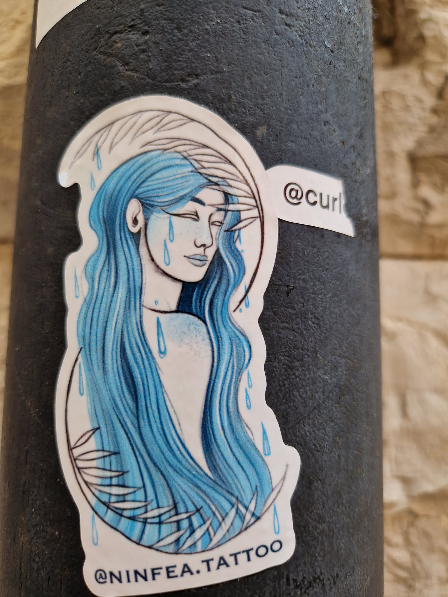 This sticker features a beautiful illustration of a woman with long, flowing blue hair.  Blue raindrops surround her, adding a sense of melancholy to the piece. The style is reminiscent of watercolor painting.  The artist's Instagram handle is visible on the sticker.