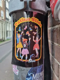 A black background sticker with three girls on roller skates reaching for stars.  The text "Patine Slide" is at the top. There's a small RIP tombstone and skull at the bottom. 