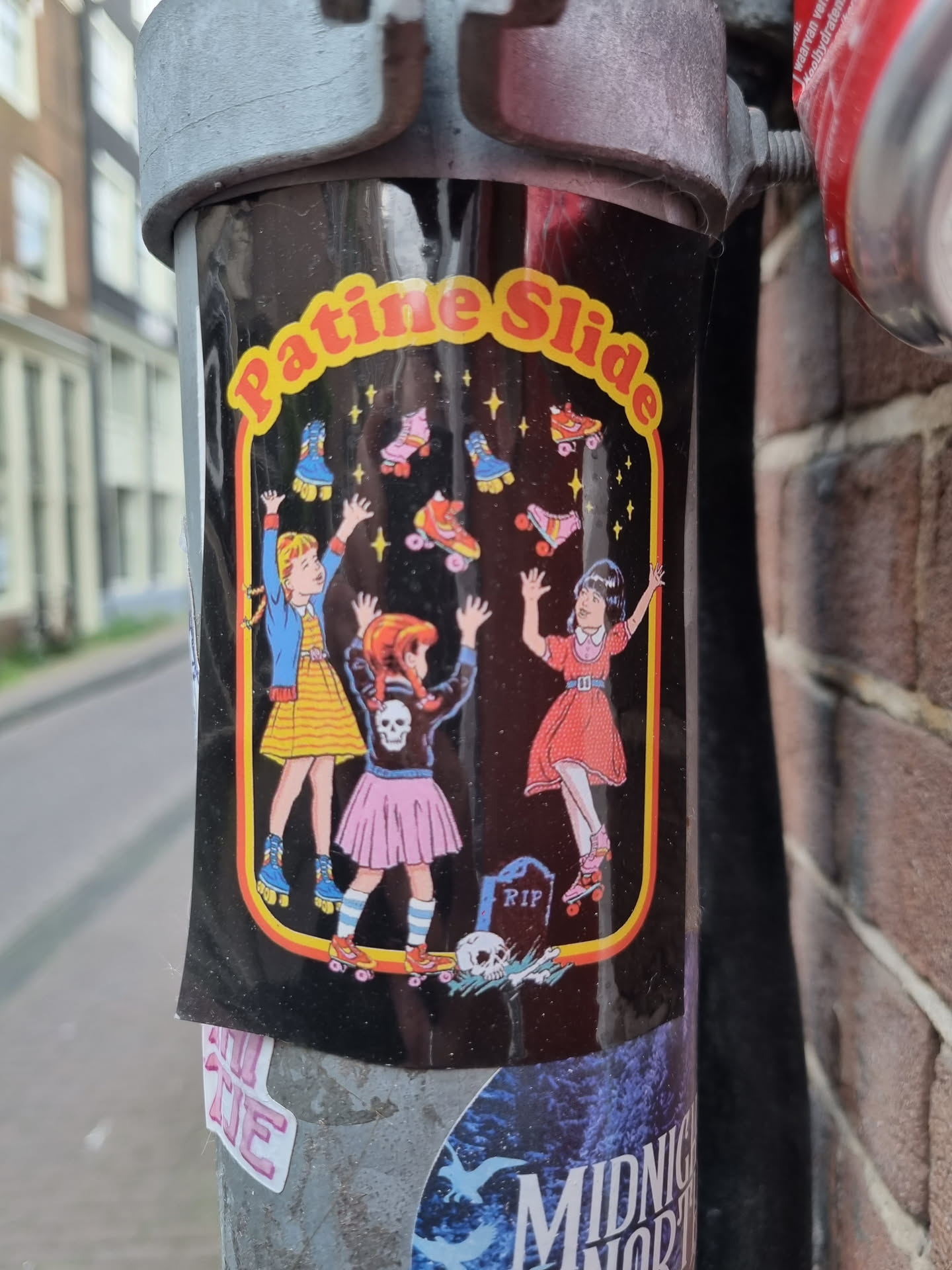 A black background sticker with three girls on roller skates reaching for stars.  The text "Patine Slide" is at the top. There's a small RIP tombstone and skull at the bottom. 