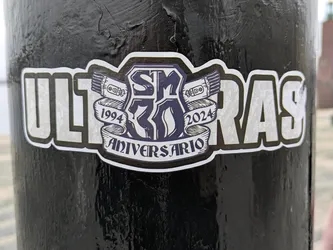 A black and white sticker commemorating 30 years of Ultras, from 1994 to 2024. It features the text 'ULTRAS' prominently, along with a central emblem that includes the numbers '30' and 'Aniversario.'  The design style is bold and graphic.
