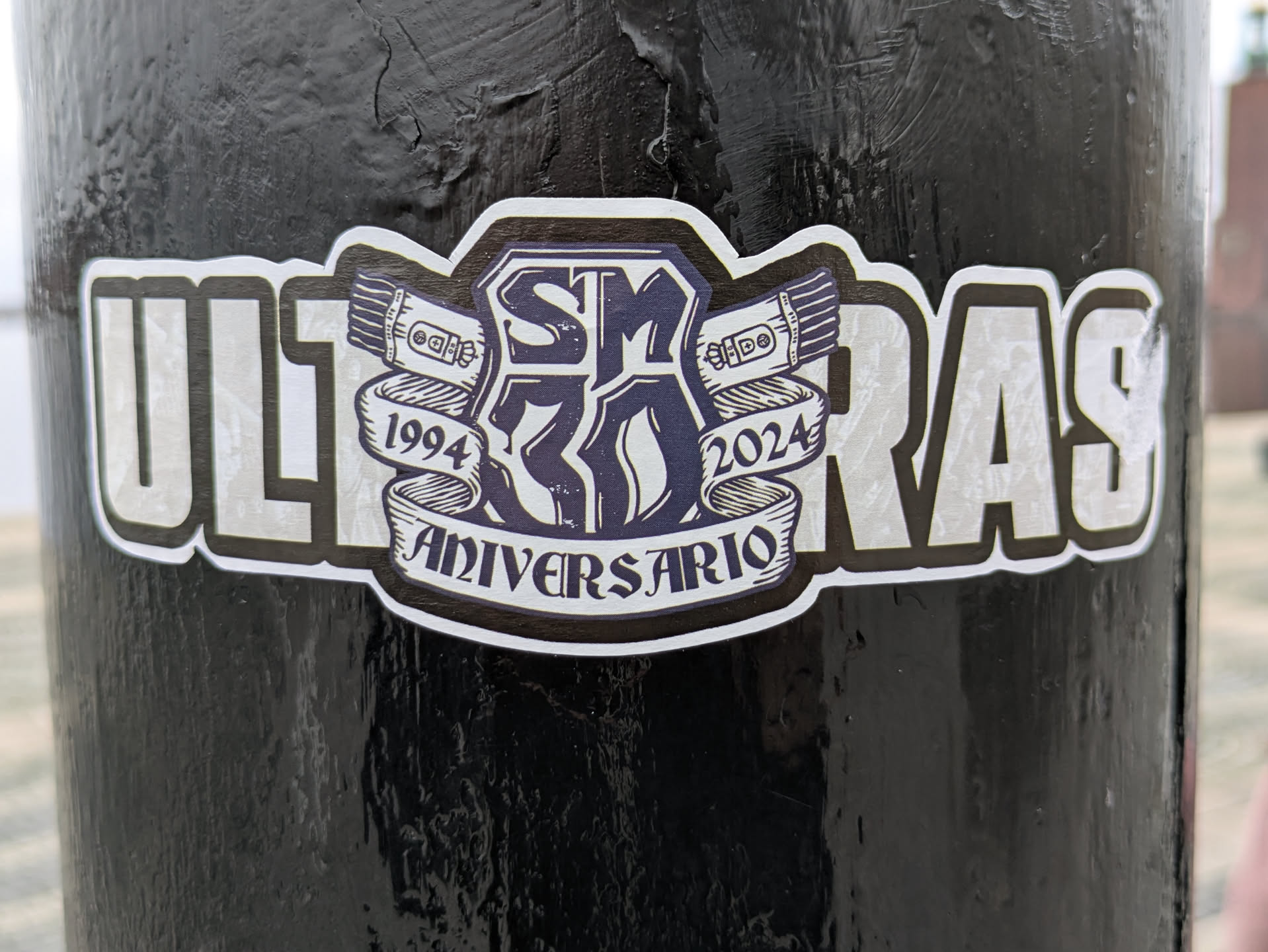 A black and white sticker commemorating 30 years of Ultras, from 1994 to 2024. It features the text 'ULTRAS' prominently, along with a central emblem that includes the numbers '30' and 'Aniversario.'  The design style is bold and graphic.