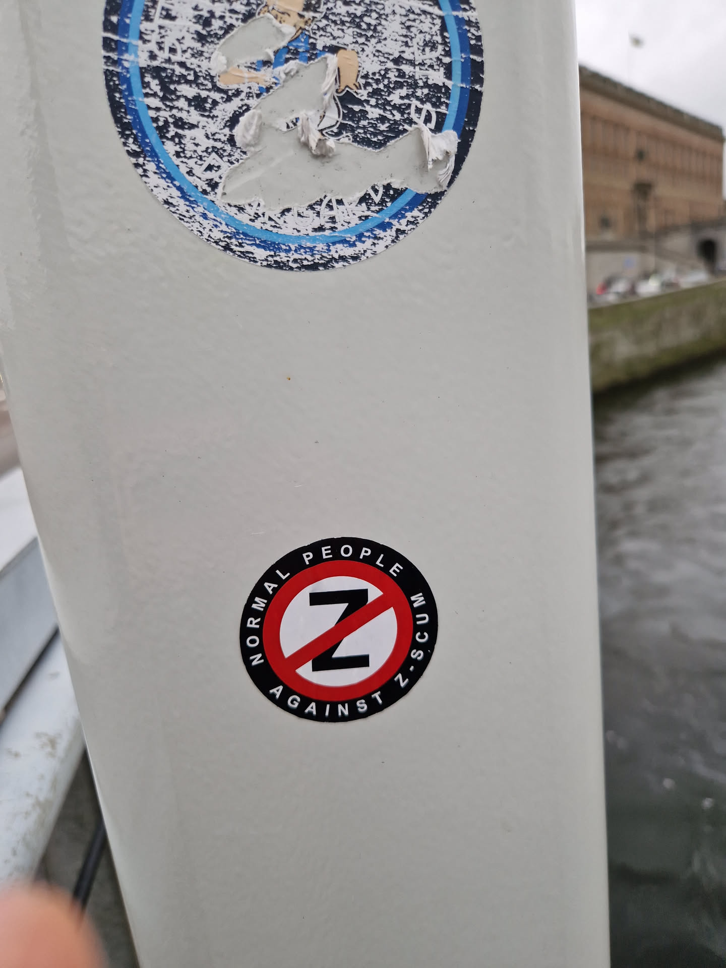 A round sticker with a red circle and a slash over the letter Z. The text around the circle says "NORMAL PEOPLE AGAINST Z SCUM".
