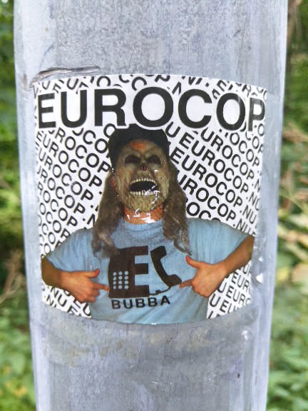 Sticker featuring a person wearing a mask, pointing at a logo on their shirt that says 'Bubba'. The background is filled with the word 'Eurocop' repeatedly. 