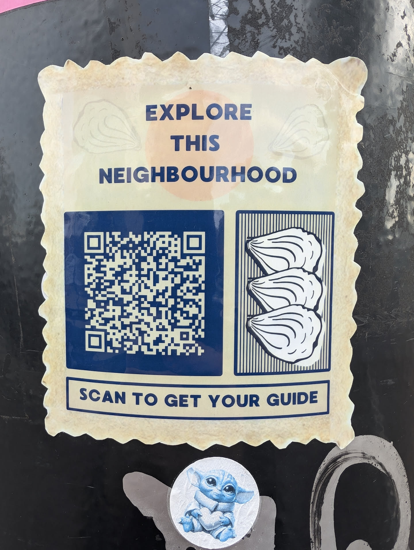 A sticker with a QR code that leads to a neighbourhood guide and an illustration of oysters. The sticker has a vintage postage stamp design.