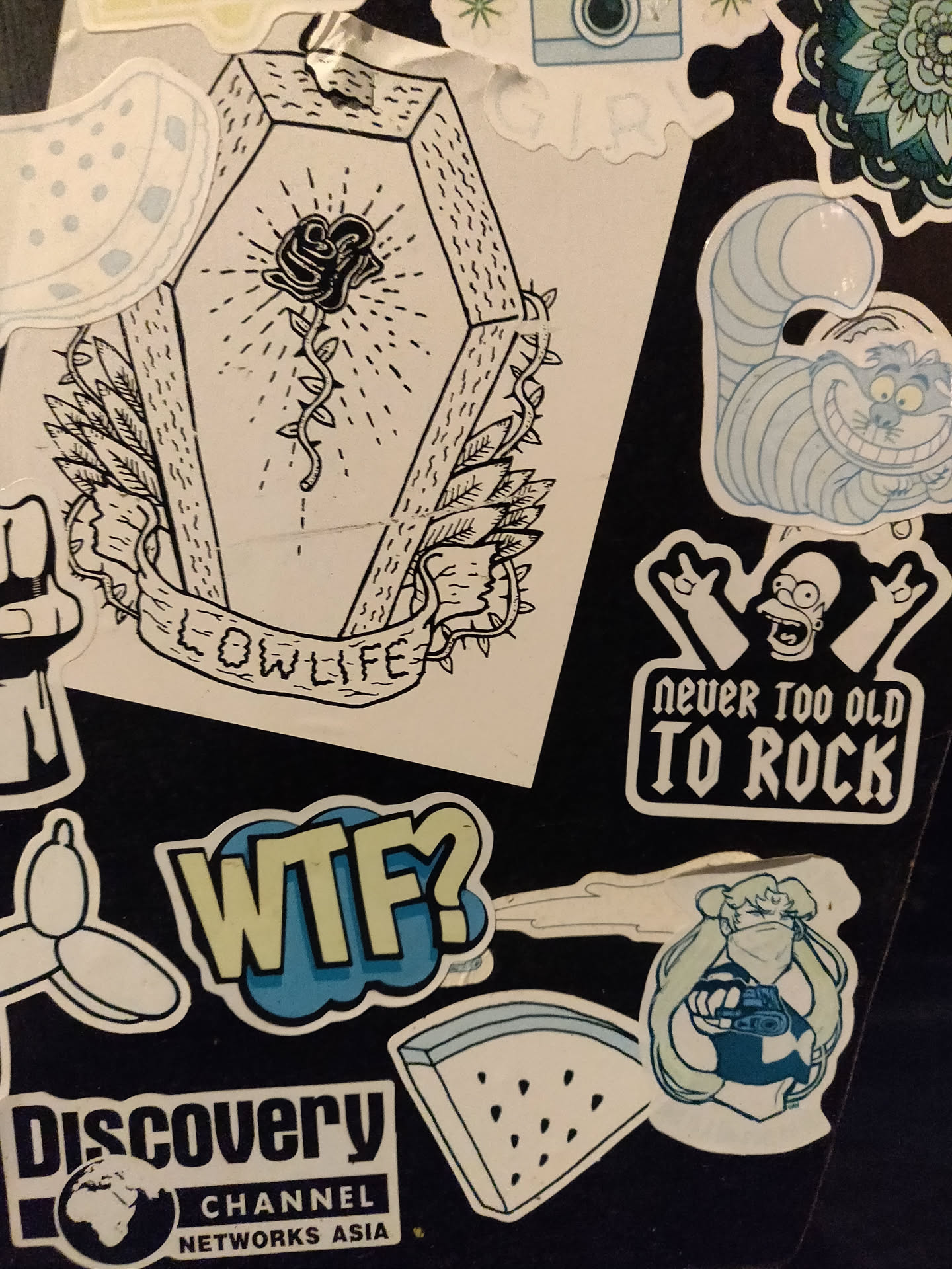 A sticker with a black line drawing of a rose in a coffin. The words "LOWLIFE" are written on a banner below the coffin. The style is reminiscent of traditional tattoo art.