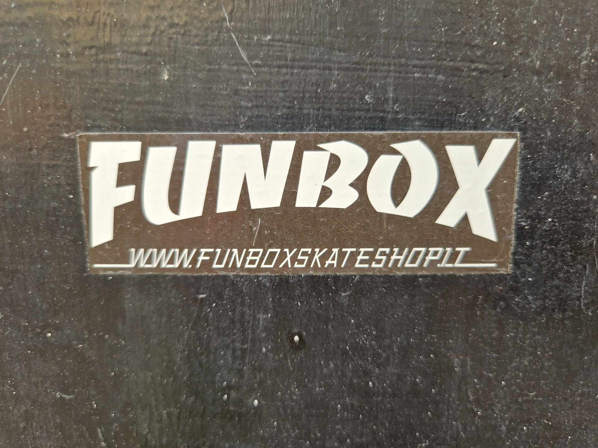 A brown and white sticker with the text FUNBOX and the website www.funboxskateshop.lt