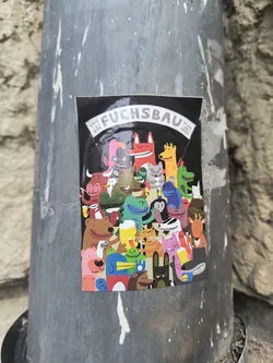 A sticker with a black background containing a lot of different cartoon animals with the text "FUCHSBAU, CAFE BAR, PLAN MITTE".