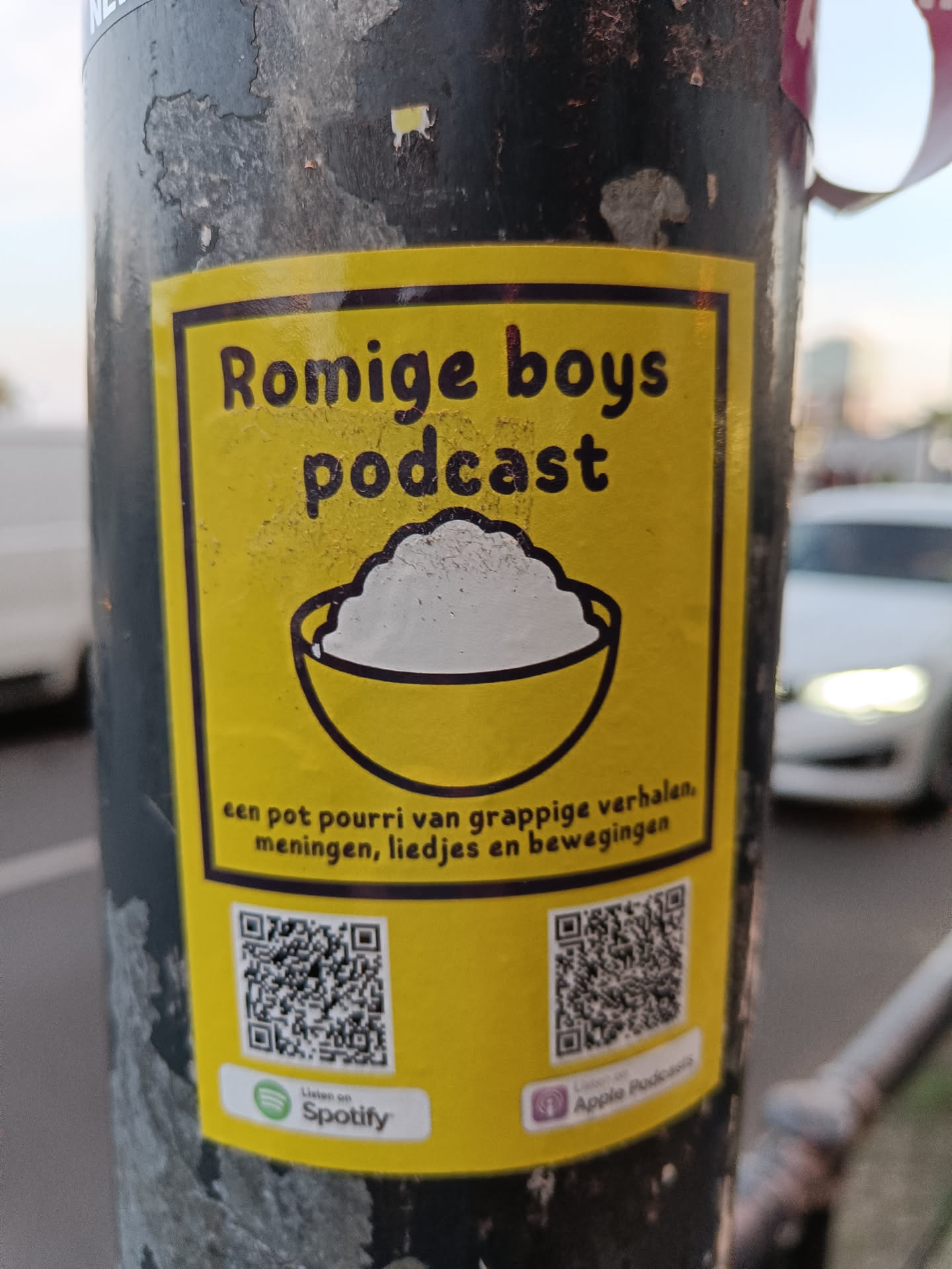 A yellow podcast sticker with a bowl of rice and two QR codes linking to Spotify and Apple Podcasts.  The description in Dutch says it's a potpourri of funny stories, opinions, songs, and movements.