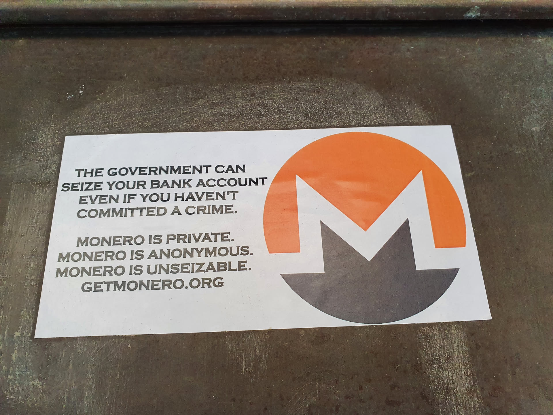 A sticker promoting Monero cryptocurrency, highlighting its privacy features and resistance to government seizure.  The sticker features the Monero logo and a message emphasizing its benefits compared to traditional banking.