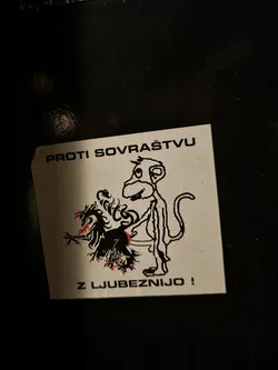 Street sticker A sticker with a drawing of a monkey standing next to a burning creature. The text on the sticker says "Against hatred with love!"