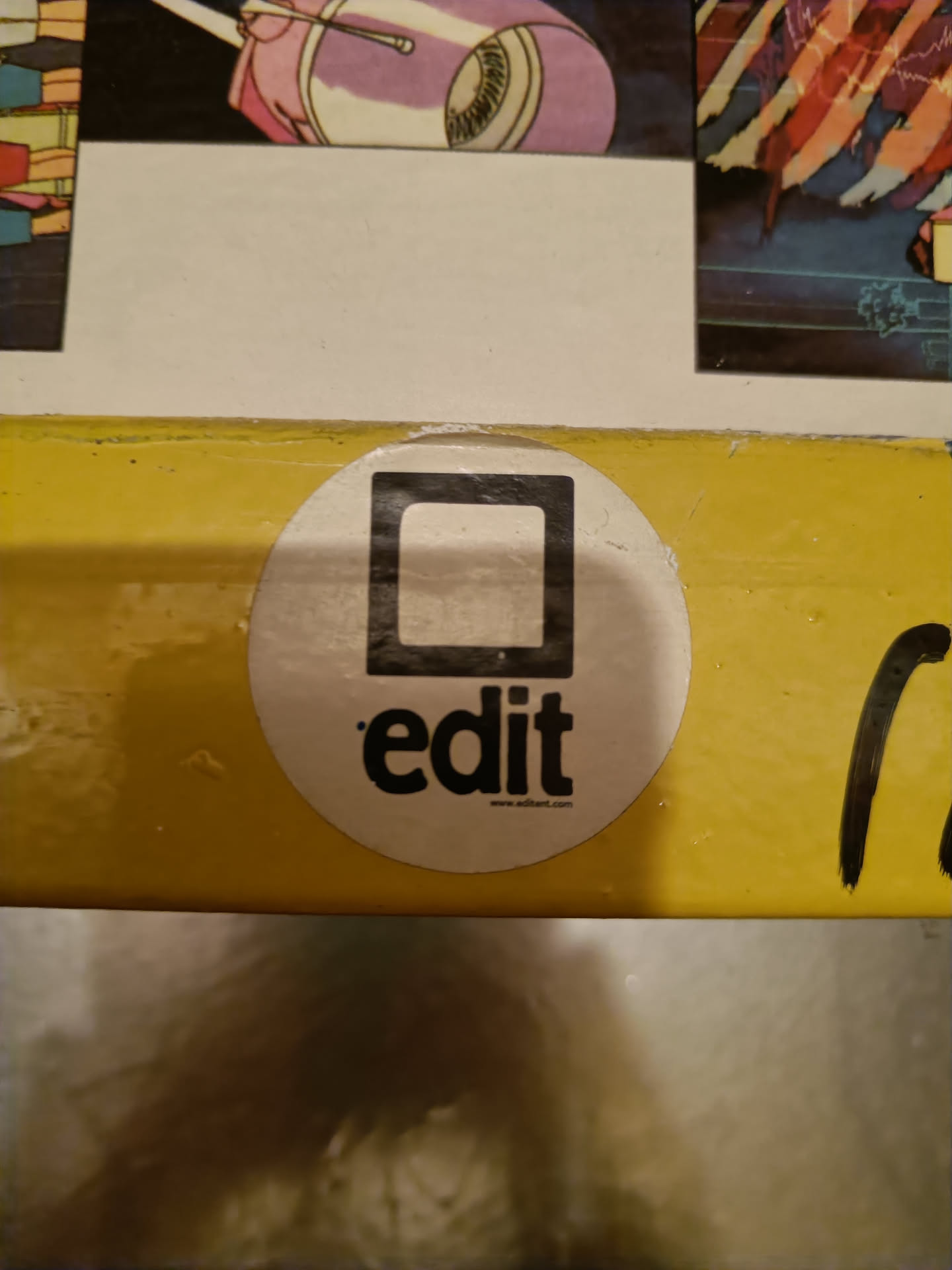 Round white sticker with a black square and the word 'edit' written below it.  The website www.editart.com is visible at the bottom.
