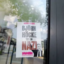 A sticker with a picture of Björn Höcke and the text "Björn Höcke ist ein Nazi" (#StopptDieAfD).  The sticker also contains a website address at the bottom.