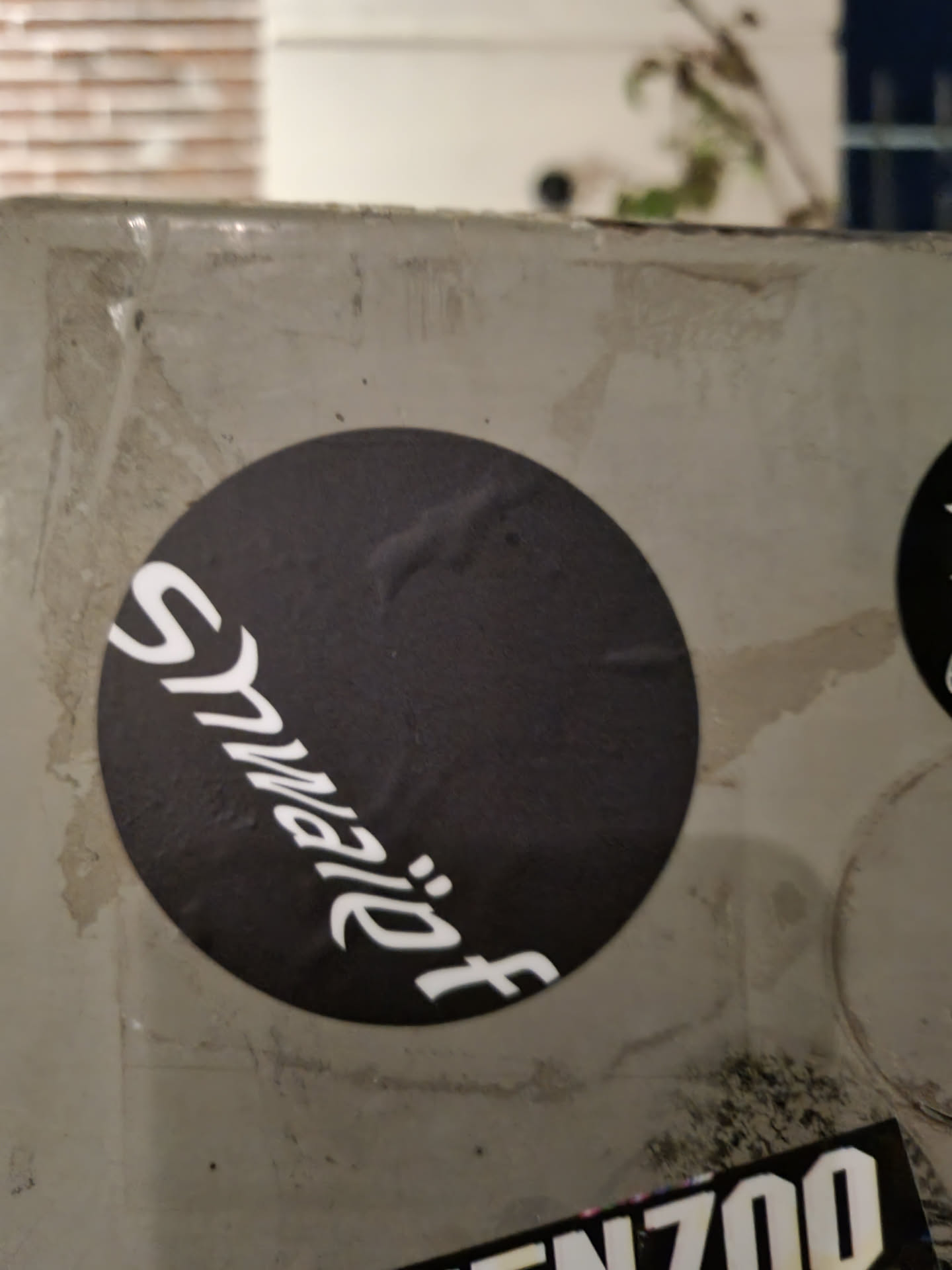 A round black and white sticker with the word \"Stwviet\" written in a stylized font.  The sticker is affixed to a light gray surface.