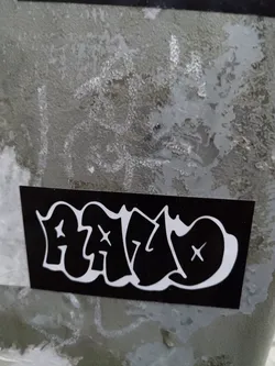 Black and white sticker with HALO written in graffiti style. The letters have a bubble effect and are marked with small crosses.