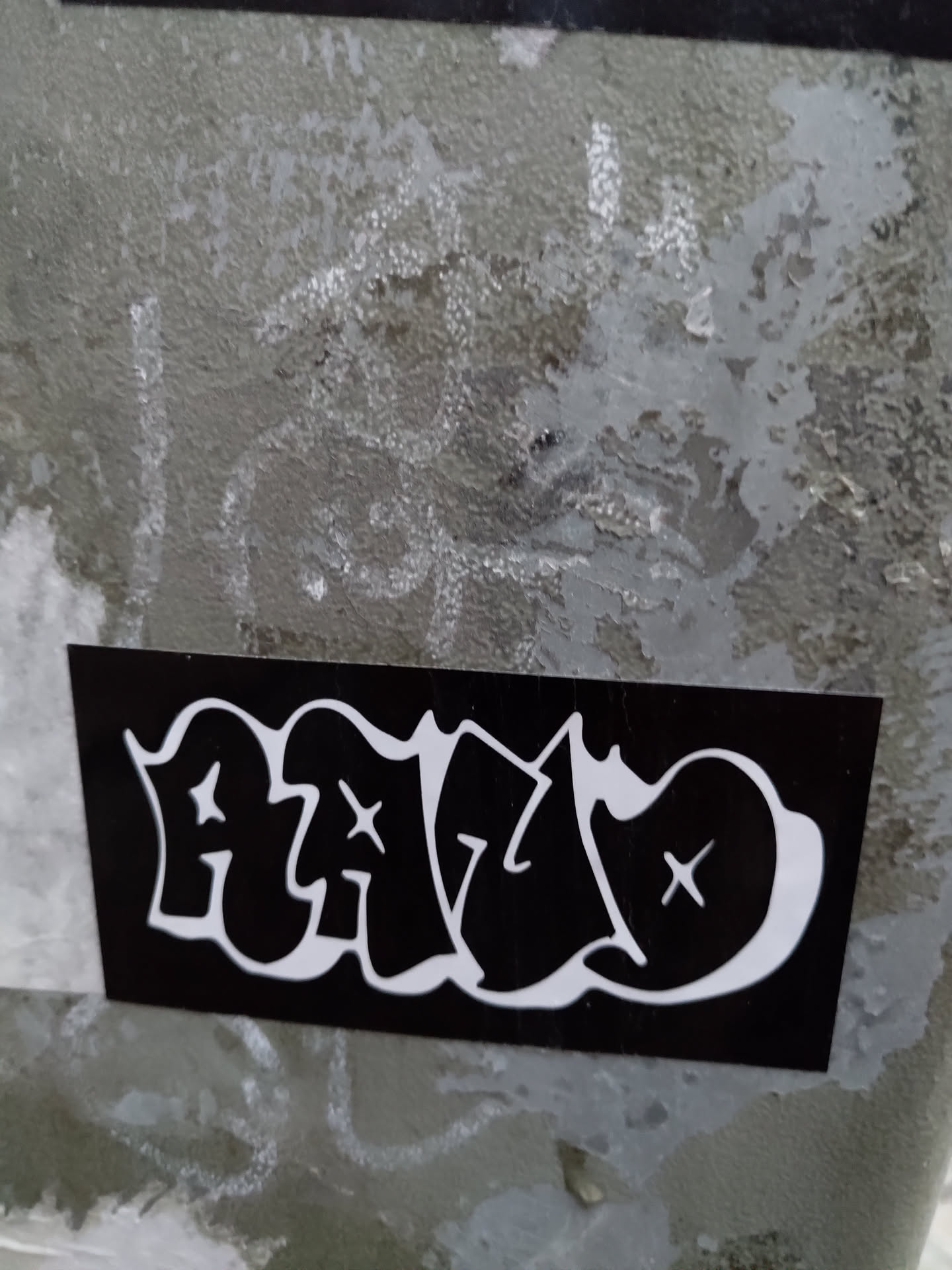 Black and white sticker with HALO written in graffiti style. The letters have a bubble effect and are marked with small crosses.