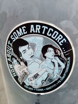 Round sticker featuring pin-up style illustrations, a VW bus, and a rabbit.  The text "How About Some Artcore" is prominently displayed, along with additional text indicating a focus on pin-ups, toons, and graffiti.  A Facebook link is also present.